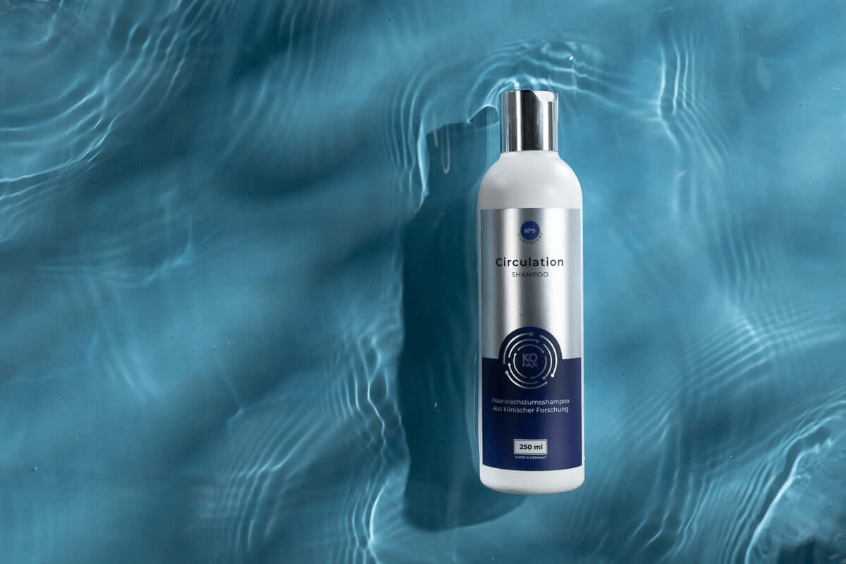 Growth Circulation Shampoo bottle floating on water; promotes hair growth and scalp health with Redensyl.