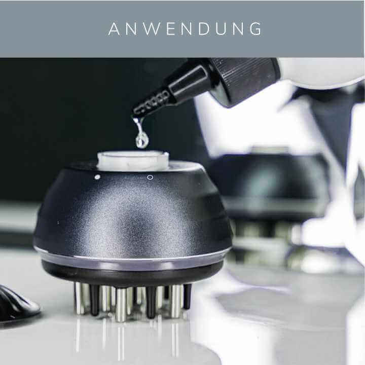 KÖ-HAIR Circulation Comb with tonic being applied for effective hair root treatment.