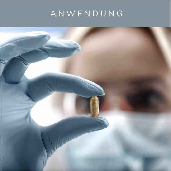 KÖ-HAIR Hair Loading Capsule held by a gloved hand, showcasing the product application in a clinical setting.